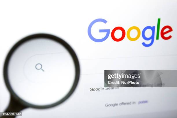 Magnifying glass is photographed with Google logo displayed on a laptop screen for illustration photo. Gliwice, Poland on January 23, 2022.