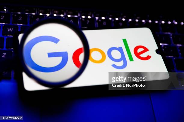 Magnifying glass is photographed with Google logo displayed on a laptop screen for illustration photo. Gliwice, Poland on January 23, 2022.
