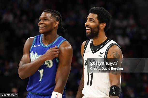 Anthony Edwards of the Minnesota Timberwolves and Kyrie Irving of the Brooklyn Nets smile in the second quarter of the game at Target Center on...