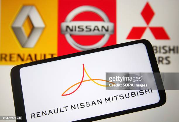 In this photo illustration, a RenaultNissanMitsubishi Alliance logo is seen on a smartphone screen and Renault,Nissan and Mitsubishi Motors logos in...