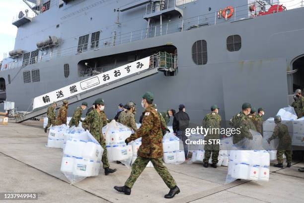 Japanese Self-Defense Force members load relief supplies onto the Maritime Self-Defense Force transport ship "Osumi" ahead of its departure for...