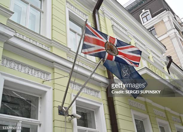 Photograph taken on January 24, 2022 shows flags of the Great Britain and NATO on the building of the UK Embassy in Kyiv. - Britain's foreign...