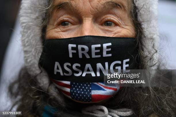 Supporter of WikiLeaks founder Julian Assange wears a face covering reading "Free Assange" during a protest against his extradition to the US outside...