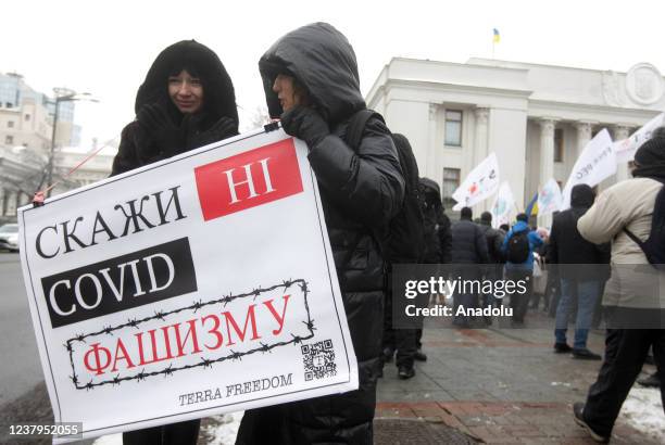 People attend a protest of opponents of vaccination against Covid-19 and quarantine measures in front of the Ukrainian Parliament in Kiev, Ukraine,...