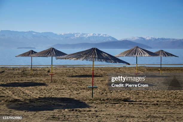 Umbrellas are seen on a beach of Lake Prespa near the tripoint of North Macedonia, Greece and Albania on January 16, 2022 in Dolno Dupeni, North...