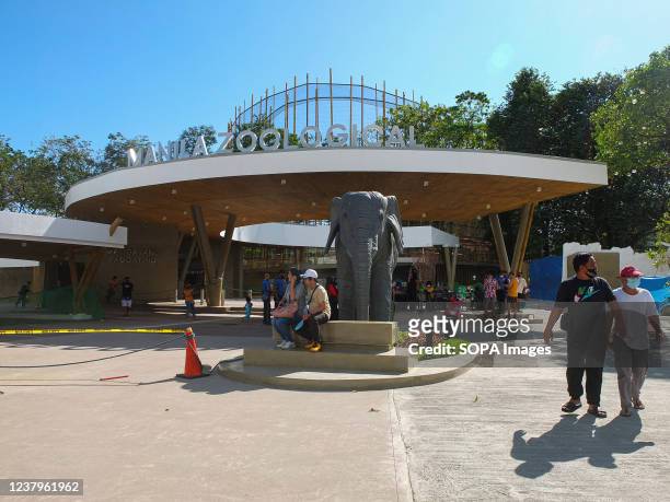 Couple is sitting on a stone bench near the replica of Mali, the elephant, at Manila Zoo. A sneak peek of the renovation project of Manila Zoo,...