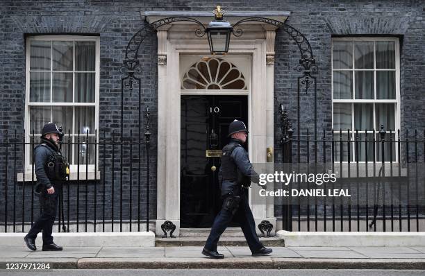 Police officer walks past the door to 10 Downing Street, the official residence of Britain's Prime Minister, in London on January 25, 2022. -...