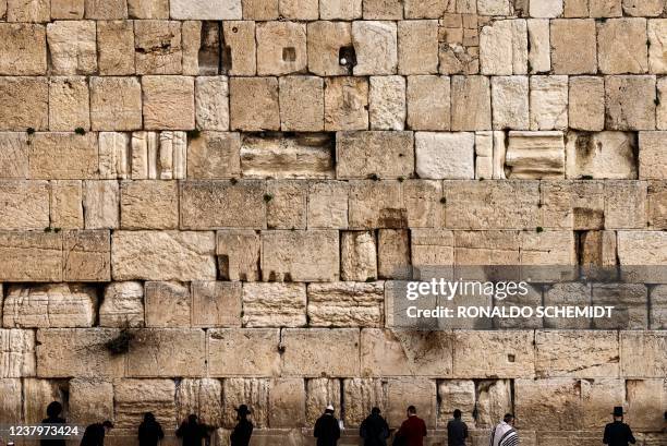 Jewish men pray at the Western Wall in Jerusalem's Old City on January 25, 2022.