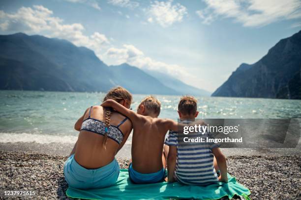 三個孩子在義大利加爾達湖的海灘上享受假�期 - lake garda 個照片及圖片檔
