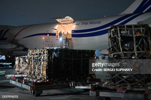 Employees unload a plane carrying new US security assistance provided to Ukraine, at Kyiv's airport Boryspil on January 25, 2022. - The shipment...