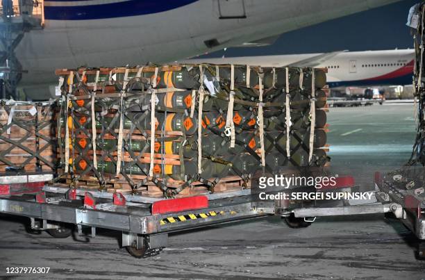 Picture taken on January 25, 2022 shows pallets of ammunition, weapons and other equipment while employees unload a plane with a new US security...