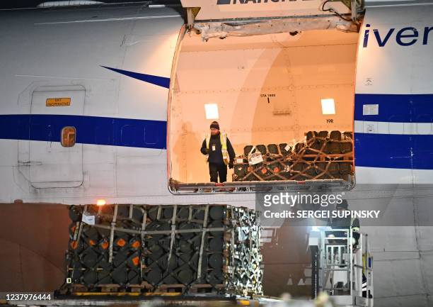 Employees unload a plane carrying new US security assistance provided to Ukraine, at Kyiv's airport Boryspil on January 25, 2022. - The shipment...