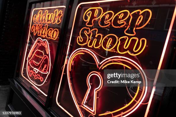 Neon signs for a peep show and adult video in Soho on 22nd January 2022 in London, United Kingdom. Soho has always been known as the seedy part of...