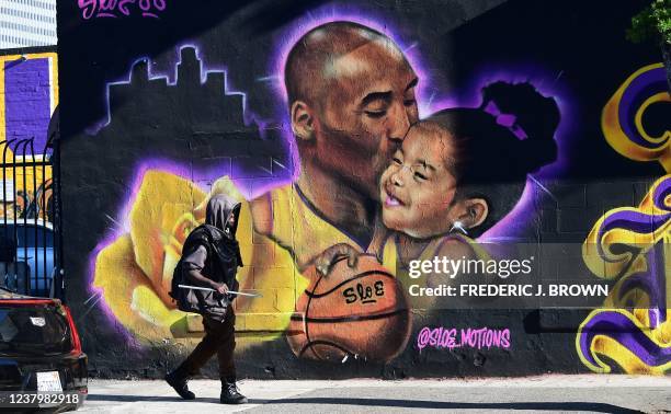 Pedestrian walks past a mural of the late Kobe Bryant and daughter Gianna by artist @sloe_motions on January 25, 2022 in Los Angeles, California, a...