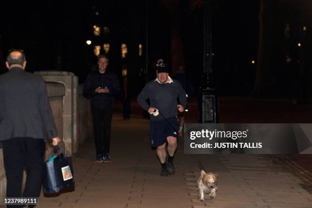 Britain's Prime Minister Boris Johnson jogs with his dog Dilyn in Westminster in London on Janurary 26, 2022. - The threat to Johnson's position...