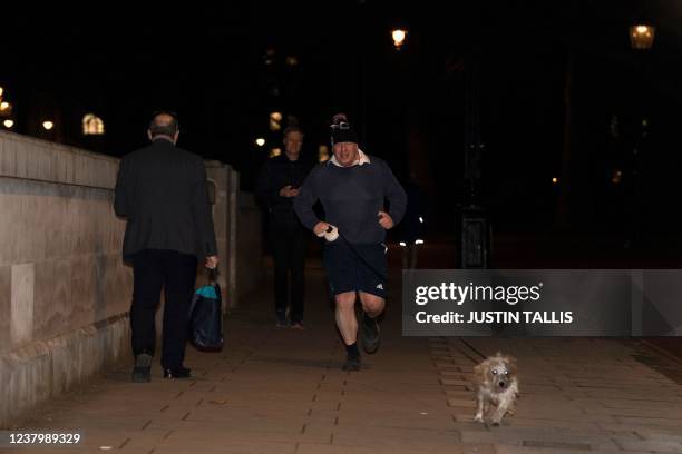 Britain's Prime Minister Boris Johnson jogs with his dog Dilyn in Westminster in London on Janurary 26, 2022. - The threat to Johnson's position...