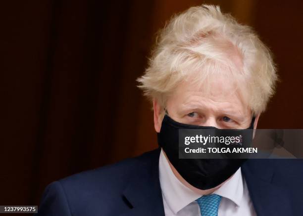 Britain's Prime Minister Boris Johnson, wearing a face covering to help mitigate the spread of coronavirus, leaves from 10 Downing Street in central...