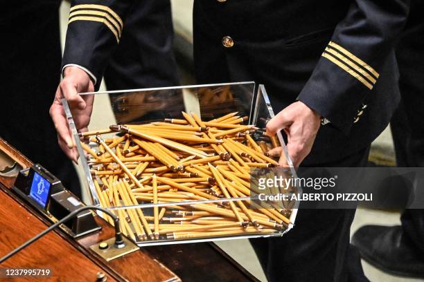 Usher carries a box of used pencils during a third round of voting for Italy's new president on January 26, 2022 in Rome's parliament. - More than...