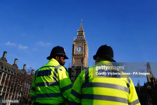 Two police officers walk past the Elizabeth Tower, better known as Big Ben, at the Houses of Parliament in Westminster, London. The Prime Minister is...