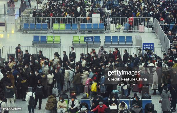 Passengers line up at a boarding gate at a railway station in Hangzhou in east Chinas Zhejiang province Tuesday, Jan. 25 as the Spring Festival comes...