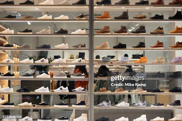 Various footwear including trainers, pumps and boots in the shop window of a shoe shop on 22nd January 2022 in London, United Kingdom.