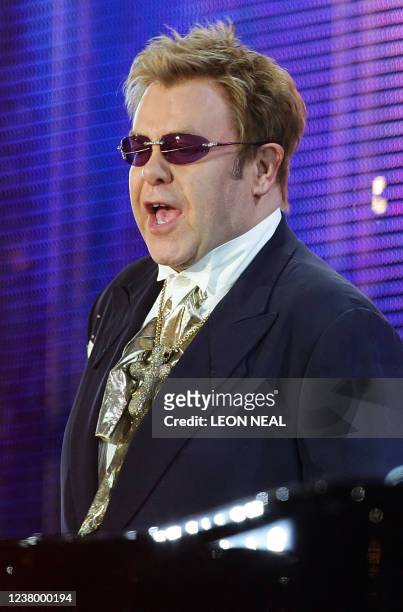 British singer Elton John performs at Wembley stadium in north London, 01 July 2007, as 60 000 revellers join Princes William and Harry for the...