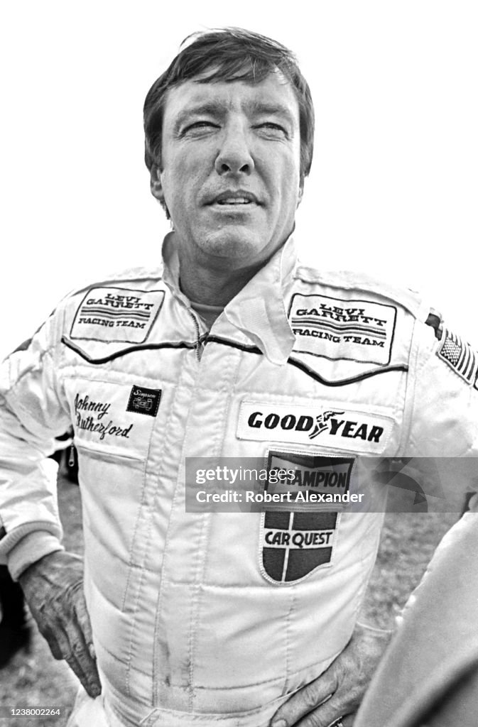 NASCAR driver Johnny Rutherford stands beside his race car prior to ...