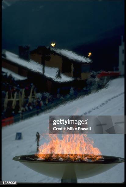 THE OLYMPIC FLAME IS SEEN IN ALL ITS GLORY IN THE FREEZING TEMPERATURES OF CANADA DURING THE 1988 WINTER OLYMPICS HELD IN CALGARY.