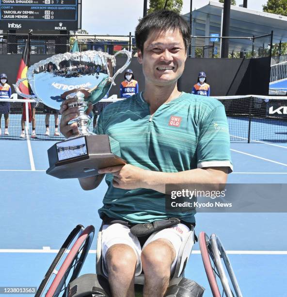 Shingo Kunieda of Japan poses with the trophy after defeating Alfie Hewett of Britain in the men's wheelchair singles final at the Australian Open...