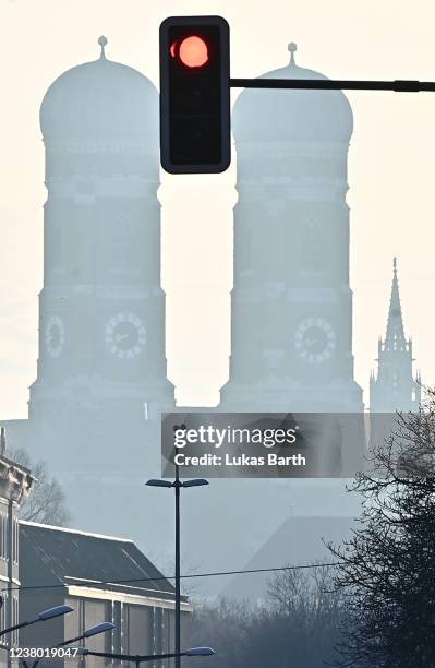 Red traffic light is seen behind the towers of the Frauenkirche cathedral on January 27, 2022 in Munich, Germany. Cardinal Reinhard Marx, the...