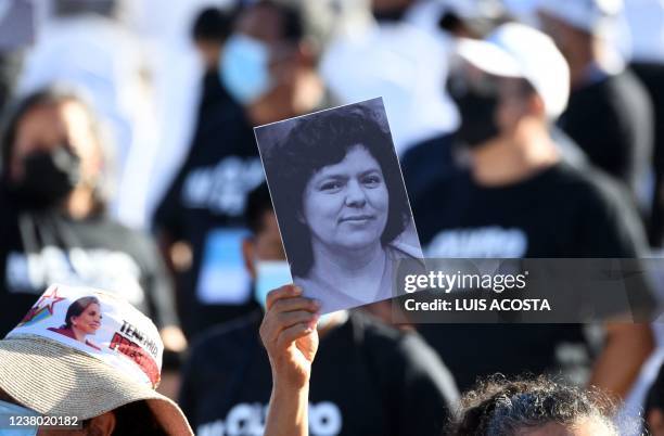 Supporter of Honduran president-elect Xiomara Castro, holds up a portrait of murdered environmentalist Berta Caceres, before Castro´s inauguration...