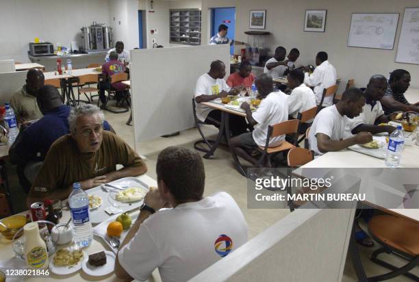 Des ouvriers d'une plate-forme pétrolière mangent au mess, le 14 octobre 2003 au large des côtes angolaises. AFP PHOTO MARTIN BUREAU