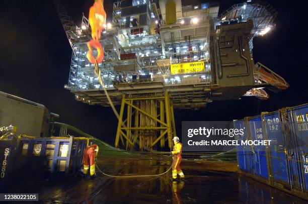 Deux marins du remorqueur de haute-mer norvégien "Bourbon Surf", travaillent, le 15 janvier 2007, au déchargement de matériel offhore au pied d'une...