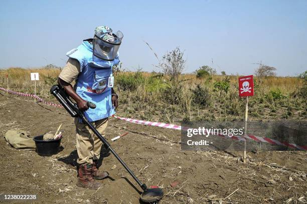 Demining experts from the United Nations Mine Action Service in protective gear carry out a demining excercise on a mine field rigged up during the...