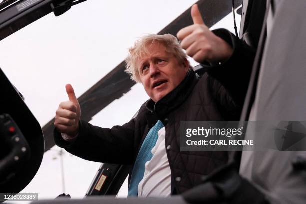 Britain's Prime Minister Boris Johnson gestures during a visit to RAF Valley, the Royal Air Force station on the island of Anglesey in north Wales on...