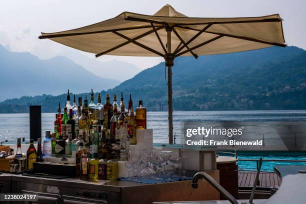 Mini bar with bottles of alcoholic drinks and parasol at the lakeside of Grand Hotel Tremezzo.