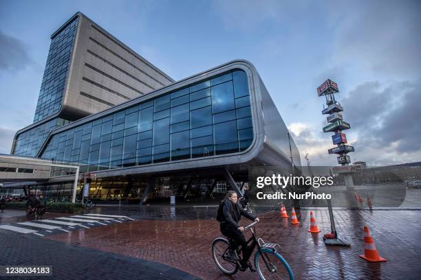 Woman is riding a bicycle at the RAI exhibition pavilions. Daily life during the lockdown at the fourth wave of the pandemic. Locals and a few...