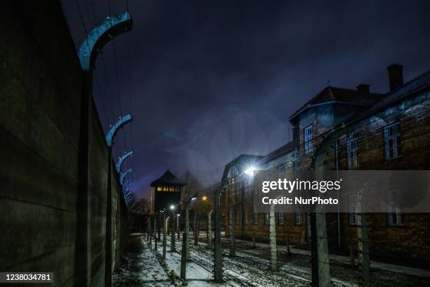 Barbed wire fence and historic buildings at the former Nazi German Auschwitz I concentration camp at Auschwitz Memorial Site during International...