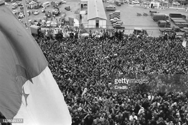 Jubilant crowd cheers Algerian FLN leader Ahmed Ben Bella at the Prefecture of Algiers where a flag of the National Liberation Front and now the...