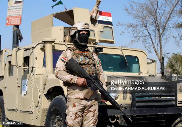 Iraqi soldiers man a checkpoint in the capital Baghdad on January 28 following a reported rocket attack on the country's airport. - Six rockets were...