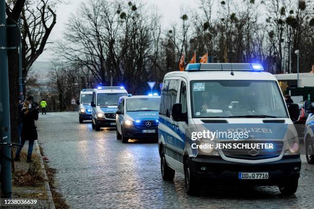 Police vehicles escort the transportation of defendants towards the Higher Regional Court in Dresden, eastern Germany on January 28, 2022 prior to...