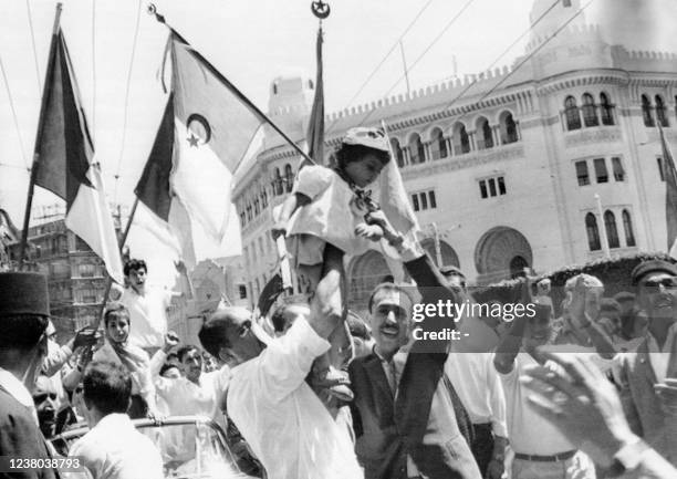 Crowd of Algerians celebrate the independence of Algeria by waving Algerian flags on July 2, 1962 in the European district of Algiers in front of the...