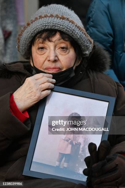 Holocaust survivor Inge Auerbacher holds a photo showing her best friend and Holocaust victim, Ruth Nelly Abraham, during a comemmoration next to her...