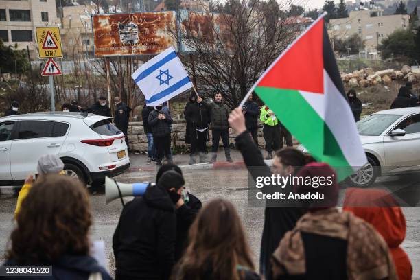 Palestinians gather during a protest against the forced eviction of Palestinian families and illegal Jewish settlement while Jewish settlers waving...