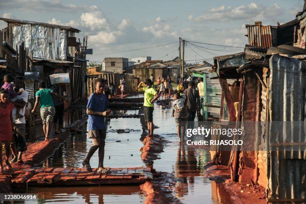 Residents stand in a flooded area of the 67-hectare Ankasina neighbourhood in Antananarivo on Januray 28, 2022 as Madagascar suffered flooding caused...