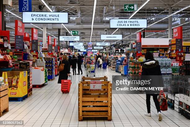 Consumers shop at Carrefour supermarket in Langueux, western France, on January 29, 2022.