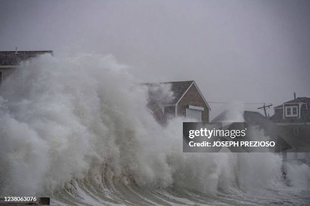 Waves crash over oceanfront homes during a noreaster in Scituate, Massachusetts, on January 29, 2022. - Blinding snow whipped up by near-hurricane...