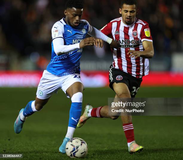 Bali Mumba of Peterborough United and Iliman Ndiaye of Sheffield United battle for the ball during the Sky Bet Championship match between...
