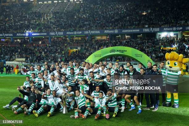 Sporting's players pose for a group picture with the trophy after winning the Portuguese Taca da Liga final football match between SL Benfica and...