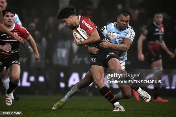 Toulouse's French fly-half Romain Ntamack is tackled by Racing92's Australian full back Kurtley Beale during the French Top14 rugby union match...